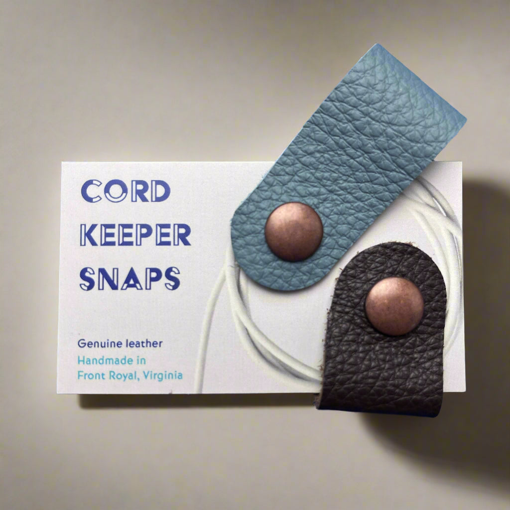 Leather cord keeper with 'Cord Keeper Snaps' branding on a white card.
